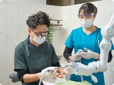 口腔外科の処置を行う歯科医師