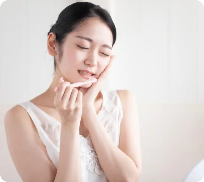 虫歯の痛みで頬をおさえる女性