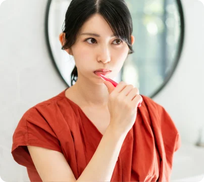鏡の前で歯みがきをする女性