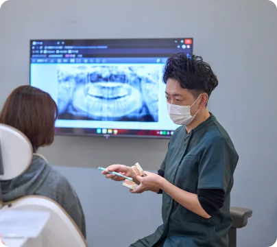 レントゲンを見ながら説明する歯科医師