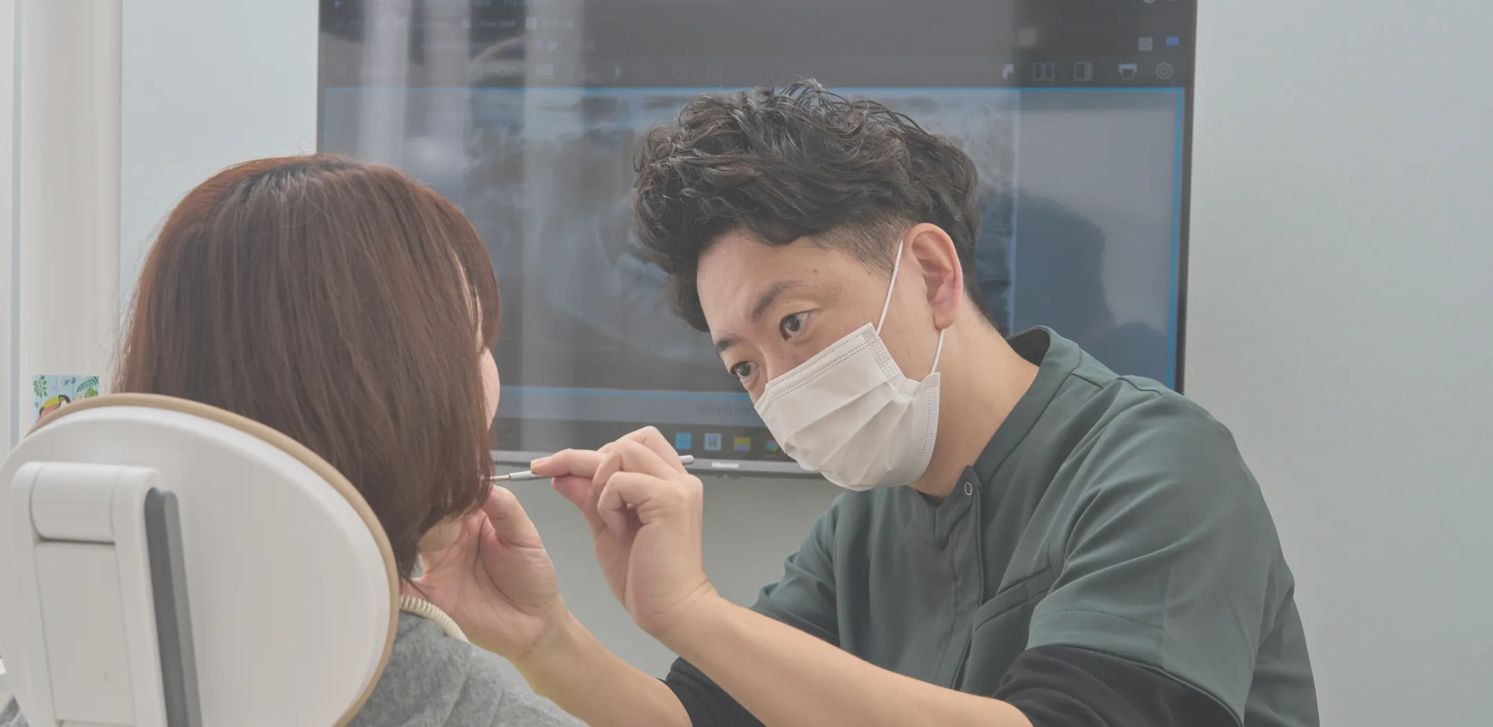 レントゲン画像を見ながら説明する歯科医師